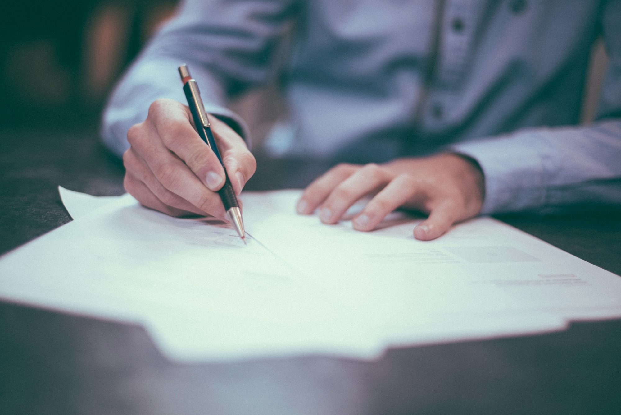 Hands signing a document — chain-of-custody and disclosure paperwork accompany every order.